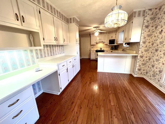 kitchen with white cabinets, pendant lighting, stove, and dark wood-type flooring