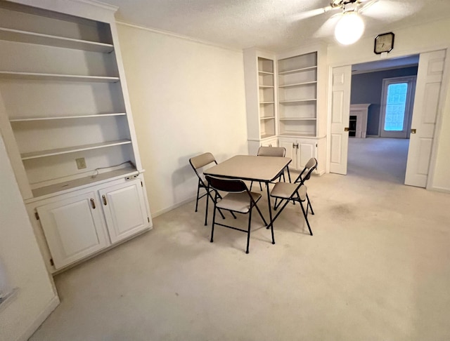 dining space with light carpet, a textured ceiling, ceiling fan, and crown molding