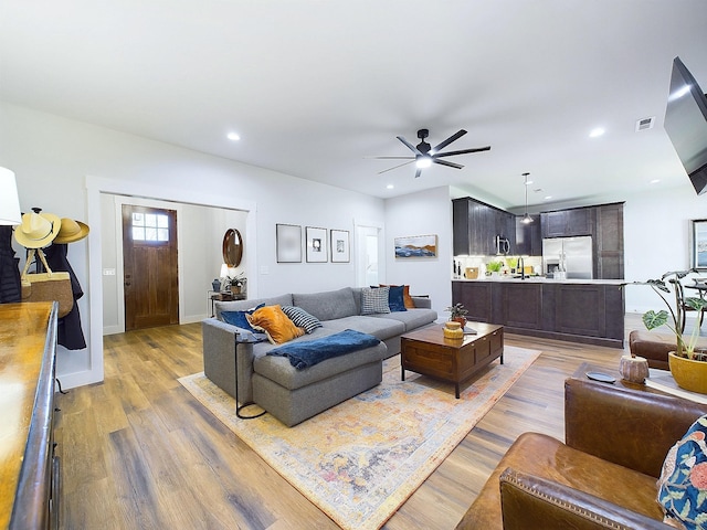 living room featuring ceiling fan and hardwood / wood-style floors