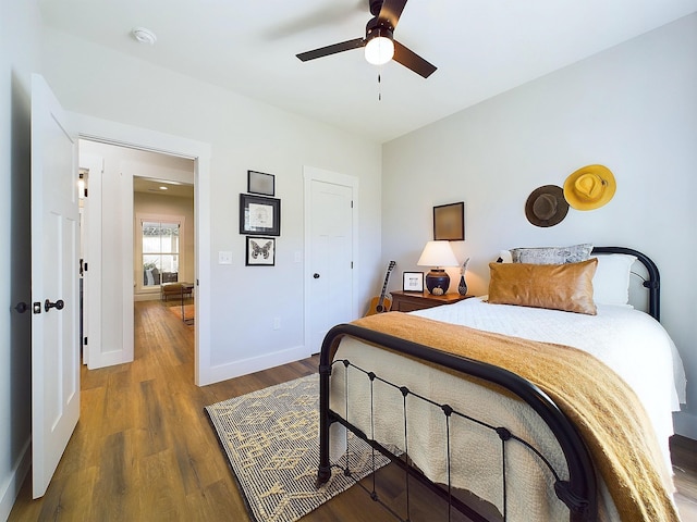 bedroom with a closet, ceiling fan, and dark hardwood / wood-style flooring