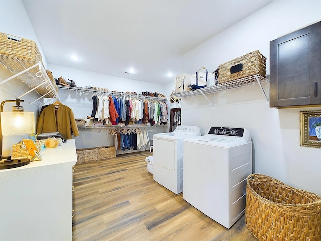 clothes washing area featuring light hardwood / wood-style flooring and washing machine and clothes dryer