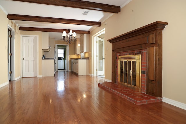 unfurnished living room featuring dark wood-style flooring, a fireplace, baseboards, beamed ceiling, and crown molding