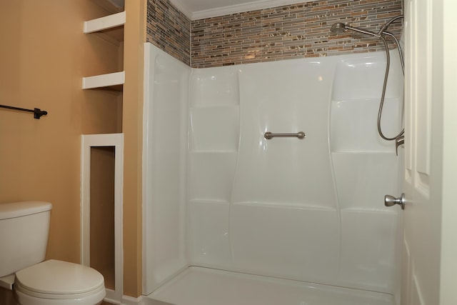 bathroom with ornamental molding, toilet, and a shower