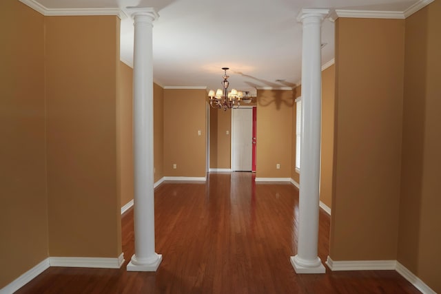 empty room featuring ornate columns, ornamental molding, and wood finished floors