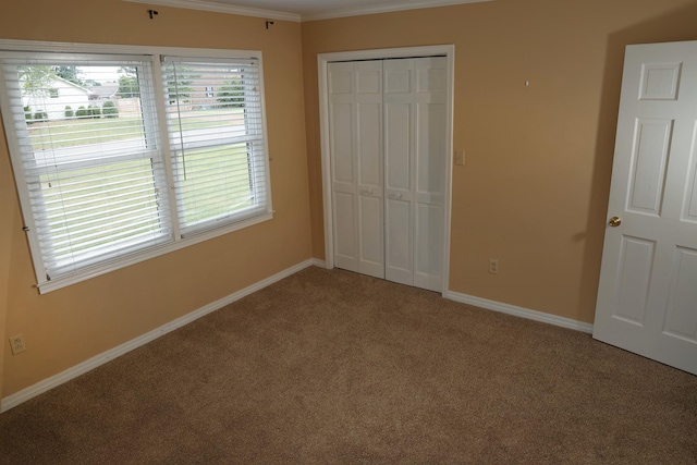 unfurnished bedroom featuring crown molding, carpet, and a closet