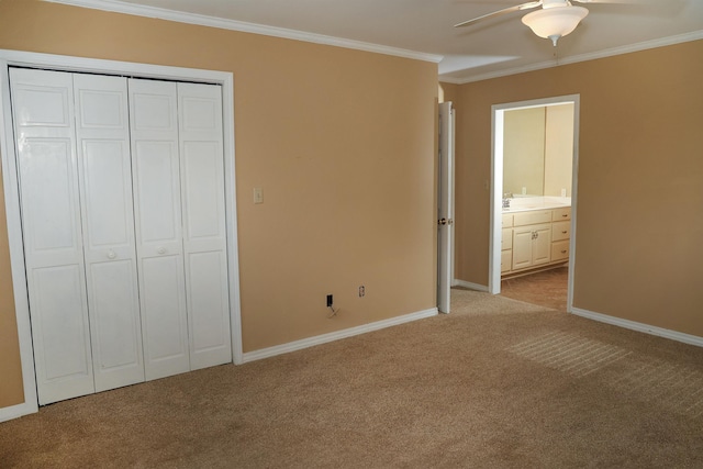 unfurnished bedroom with connected bathroom, baseboards, crown molding, and light colored carpet