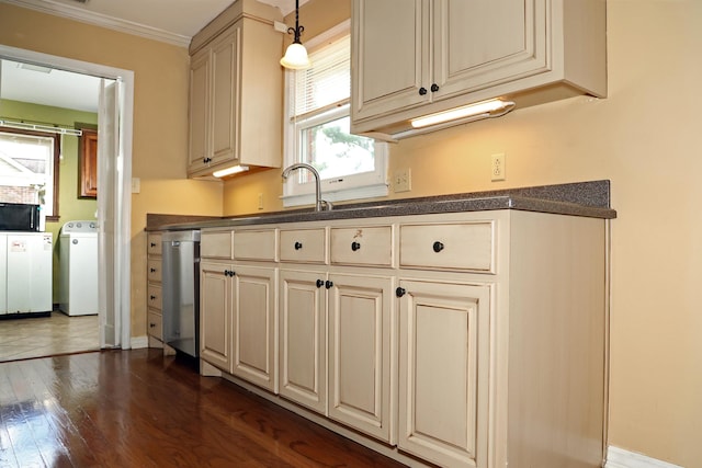 kitchen featuring washer / dryer, dark countertops, and cream cabinetry