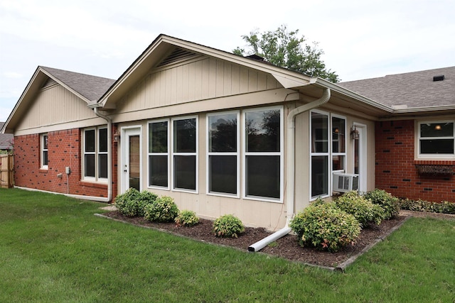 rear view of house featuring a lawn