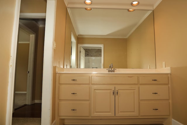 bathroom featuring recessed lighting, baseboards, ornamental molding, and vanity