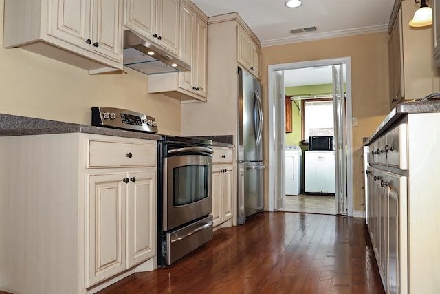 kitchen with dark wood-type flooring, stainless steel appliances, cream cabinets, ornamental molding, and decorative light fixtures