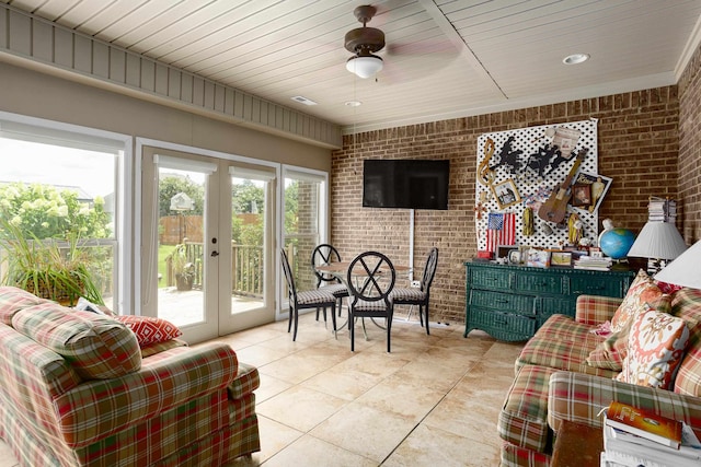  - living room with brick wall, light tile patterned flooring, and french doors