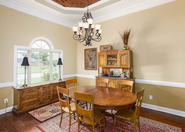  - dining room featuring a raised ceiling, a chandelier, wood-type flooring, and crown molding