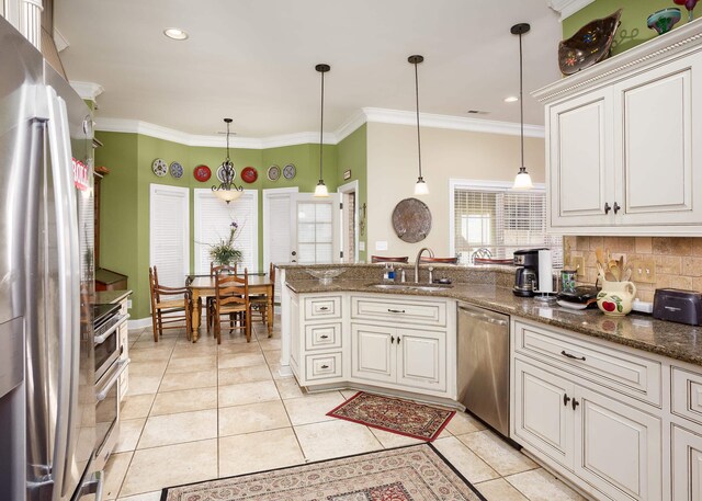  - kitchen with stainless steel appliances, a peninsula, light tile patterned floors, tasteful backsplash, and white cabinets