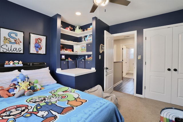 carpeted bedroom with ceiling fan and a closet