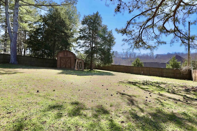 view of yard featuring an outbuilding, a shed, and a fenced backyard