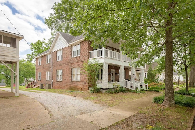  - view of home's exterior featuring a balcony, covered porch, and brick siding