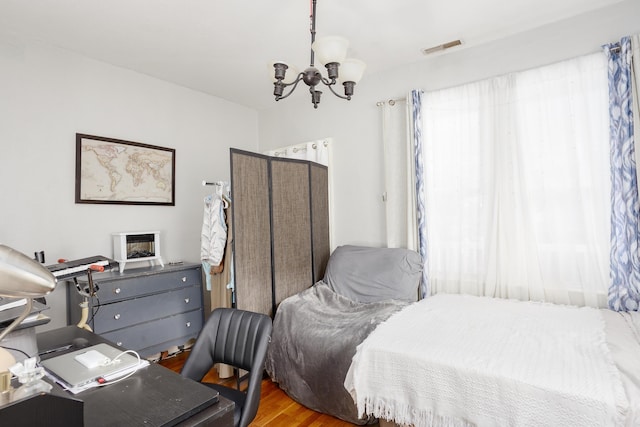  - bedroom with a chandelier and wood finished floors