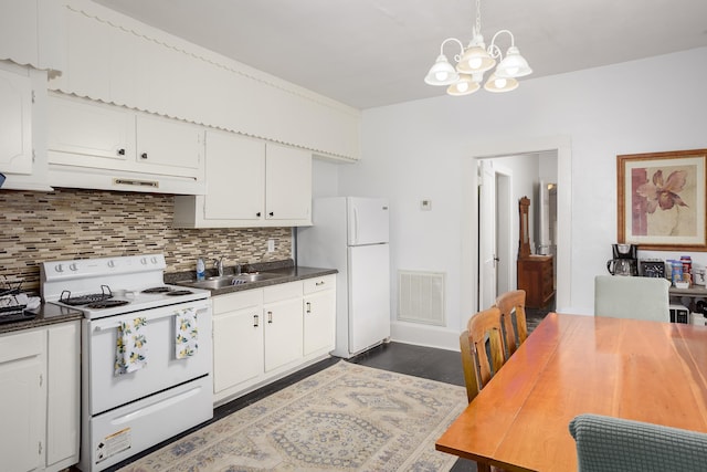  - kitchen featuring white appliances, under cabinet range hood, tasteful backsplash, a chandelier, and white cabinets