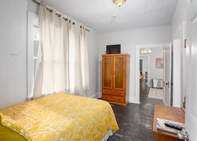  - bedroom with a chandelier, a textured ceiling, and dark wood-type flooring