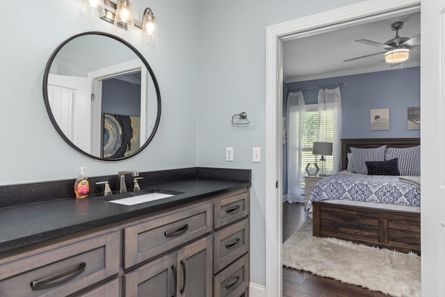 bathroom featuring hardwood / wood-style floors, ceiling fan, crown molding, and vanity