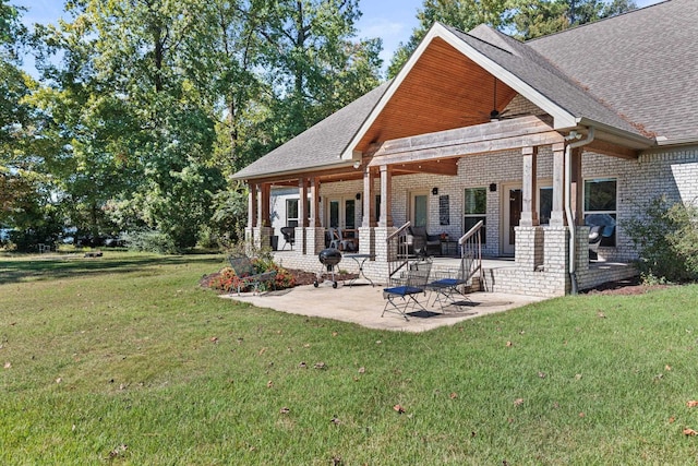 back of house with a lawn and a patio area