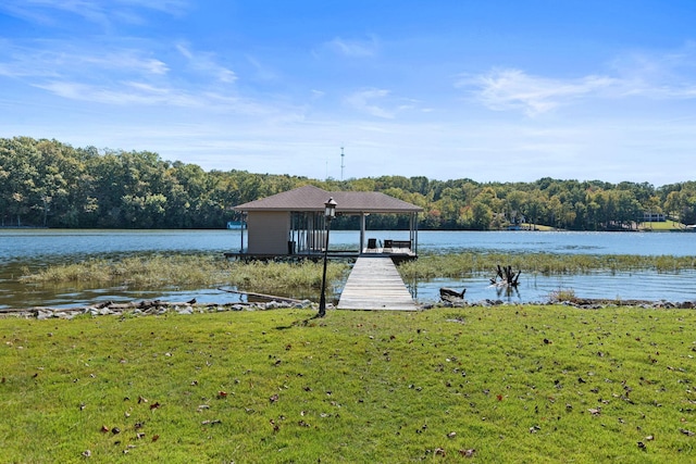 view of dock with a yard and a water view