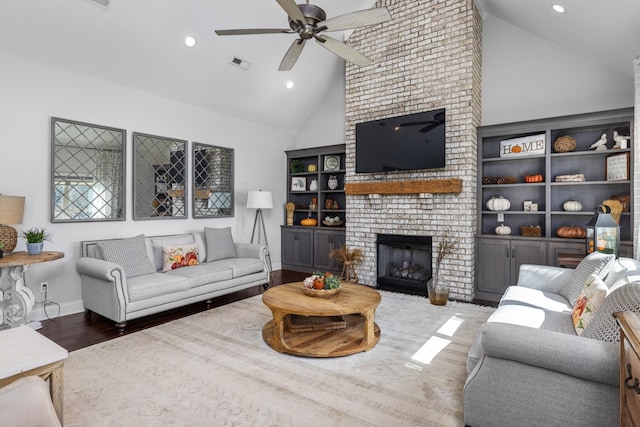 living room featuring a fireplace, wood-type flooring, high vaulted ceiling, and ceiling fan