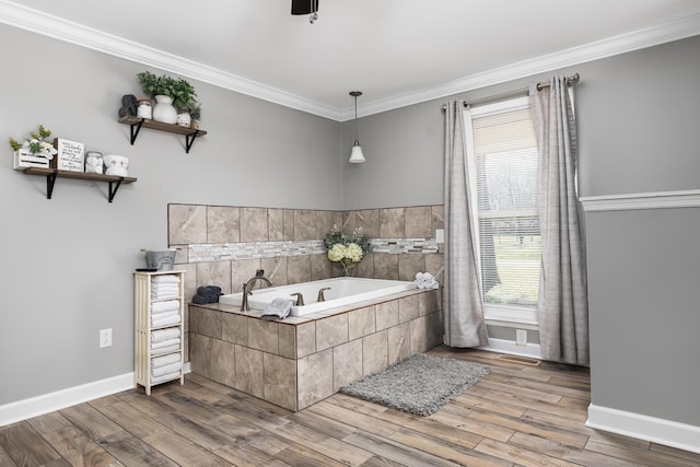 bathroom featuring plenty of natural light, a relaxing tiled tub, ornamental molding, and hardwood / wood-style flooring