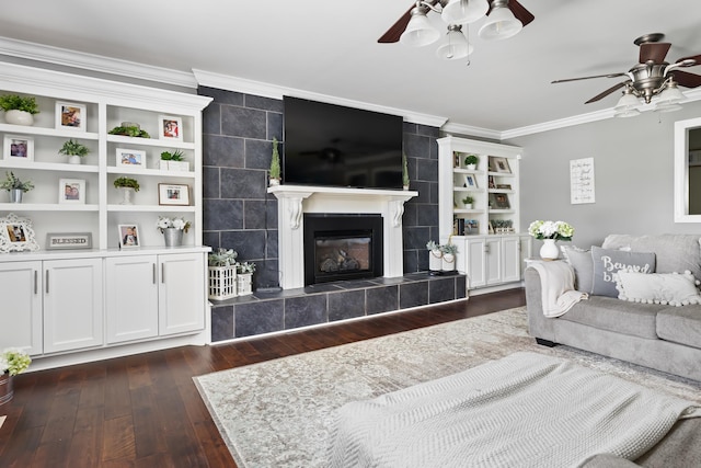 living room with dark hardwood / wood-style flooring, ceiling fan, ornamental molding, and a tiled fireplace