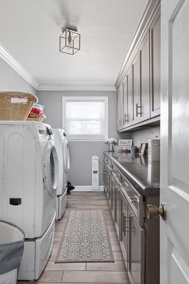 laundry area with cabinets, light hardwood / wood-style flooring, washer and clothes dryer, and ornamental molding