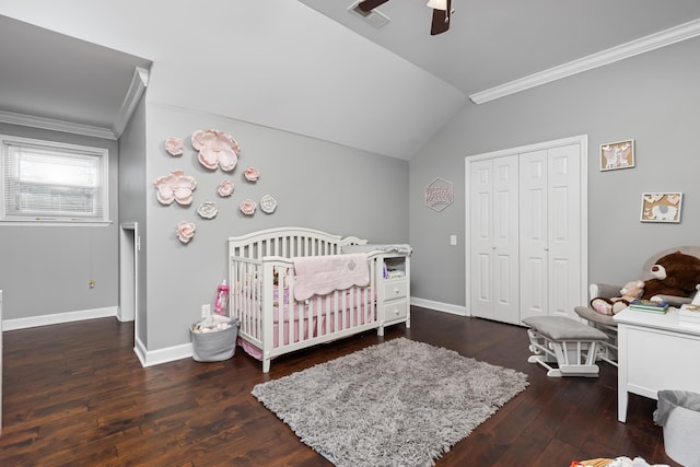 bedroom featuring ceiling fan, dark wood-type flooring, vaulted ceiling, a closet, and a crib