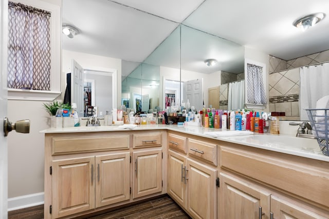 bathroom with hardwood / wood-style flooring, vanity, and walk in shower