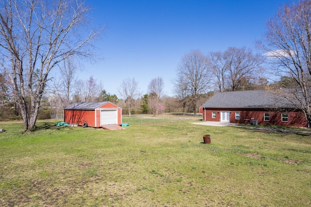 view of yard featuring a garage and an outbuilding