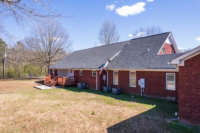 rear view of house featuring a lawn, cooling unit, and a deck