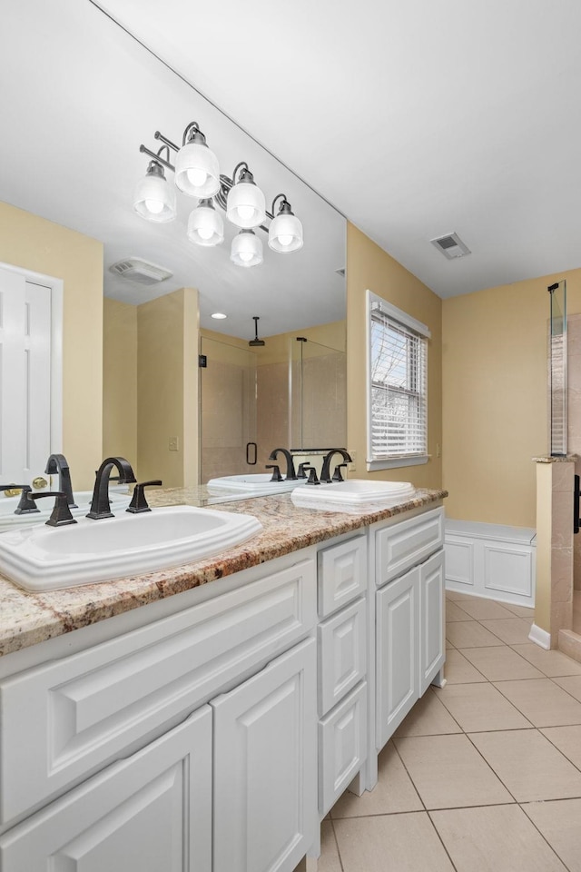 bathroom featuring vanity, a shower with door, and tile patterned flooring