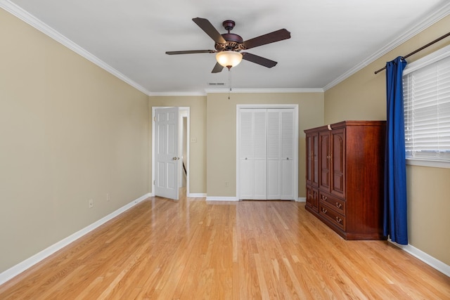 unfurnished bedroom with crown molding, ceiling fan, light hardwood / wood-style floors, and a closet