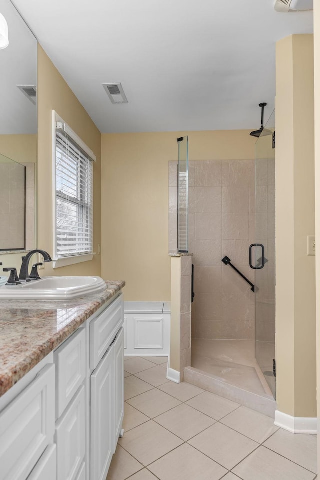 bathroom featuring vanity, tile patterned floors, and walk in shower