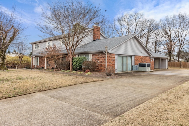 view of side of home featuring cooling unit, a yard, and a garage