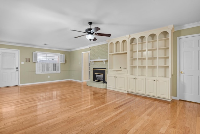 unfurnished living room featuring crown molding, a brick fireplace, ceiling fan, and light wood-type flooring