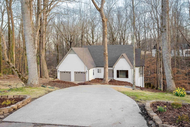 view of front of house featuring a garage, roof with shingles, and stucco siding