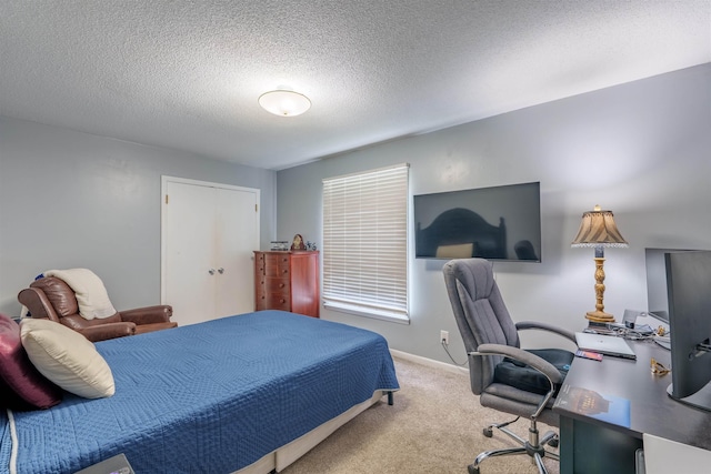  - bedroom with carpet floors, an office area, and a textured ceiling