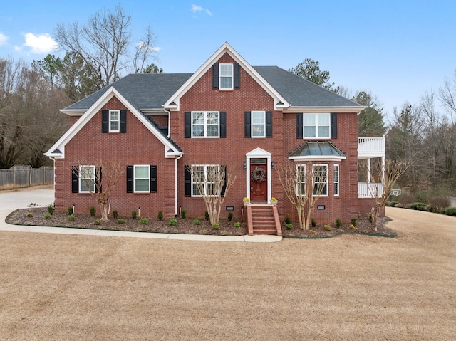 view of front of house with a balcony and a front yard