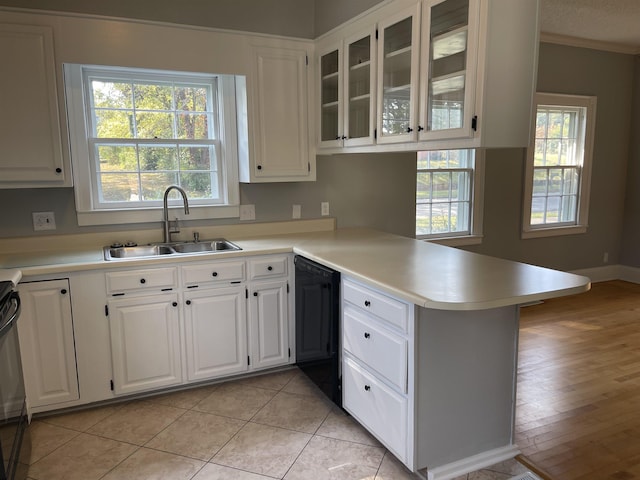 kitchen featuring dishwasher, white cabinets, sink, light tile patterned floors, and kitchen peninsula