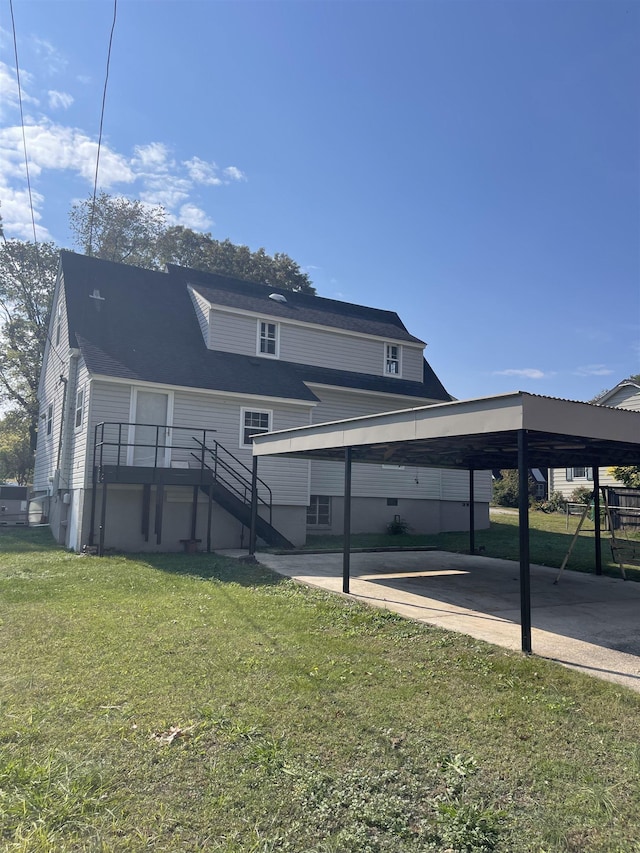 back of property with a yard and a carport