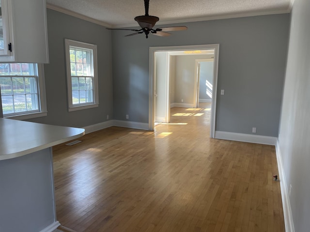 interior space featuring ceiling fan, light hardwood / wood-style flooring, a healthy amount of sunlight, and ornamental molding