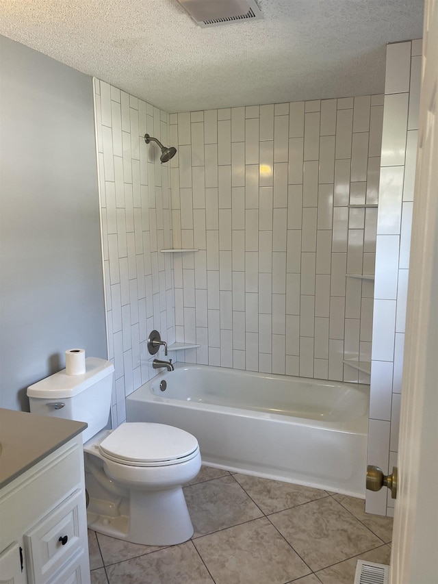 full bathroom featuring tile patterned floors, a textured ceiling, toilet, vanity, and tiled shower / bath