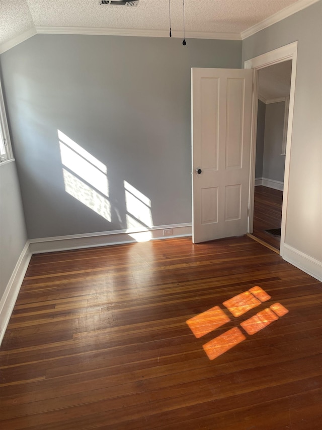 unfurnished room with vaulted ceiling, a textured ceiling, dark hardwood / wood-style floors, and ornamental molding