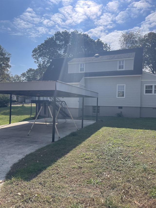 rear view of property featuring a yard and a carport