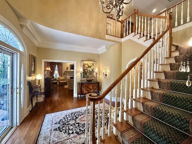 foyer entrance featuring a notable chandelier, dark hardwood / wood-style floors, and ornamental molding