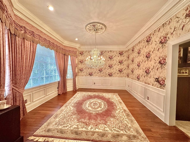 living area with dark hardwood / wood-style floors, crown molding, and an inviting chandelier